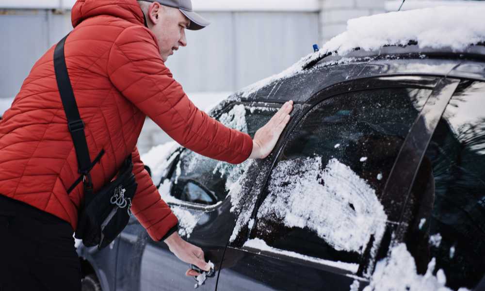 man opening a frozen car door lock